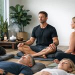 Breathwork coach leads a group session with participants resting on mats
